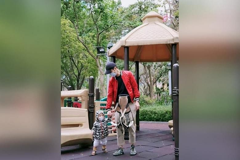 Aktor HK Kevin Cheng dan putranya memakai masker selama tamasya taman